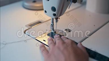 接近裁缝`的手在缝纫机上工作和制造接缝